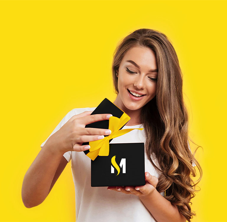 Woman with brown curly hair smiles while opening MOBILESTYLES gift box